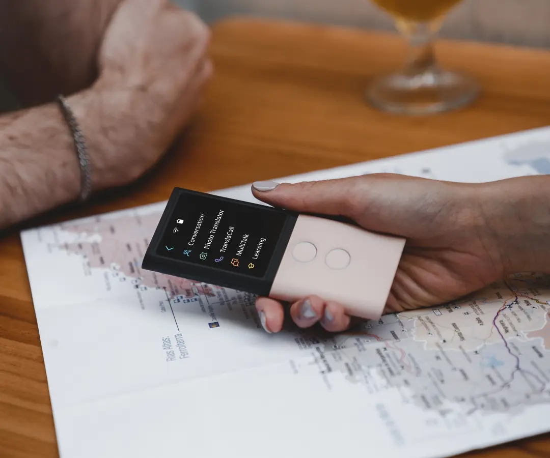 Primo piano di una mano che tiene un traduttore su un tavolo con una mappa su di esso